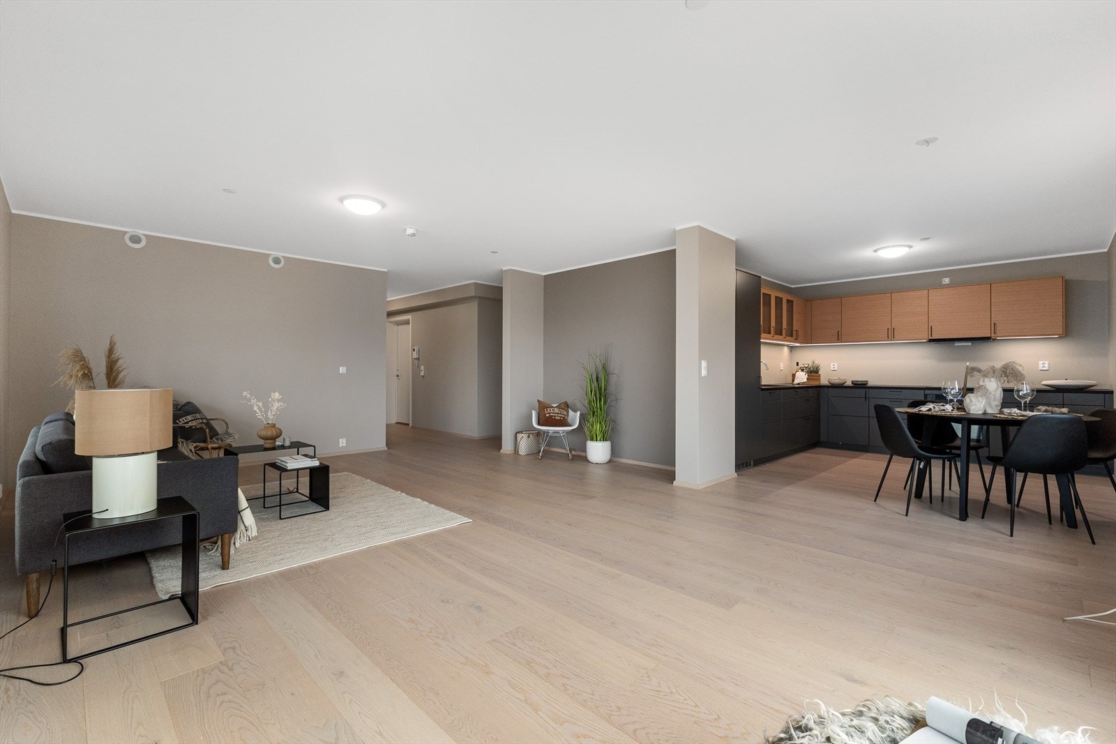 Fra stue mot kjøkkenet som er av velrenommerte Drømmekjøkken. Her er det satt inn eksklusive hvitevarer. Det er plass til ett stort spisebord i kjøkken/stuesonen. Galleribilde