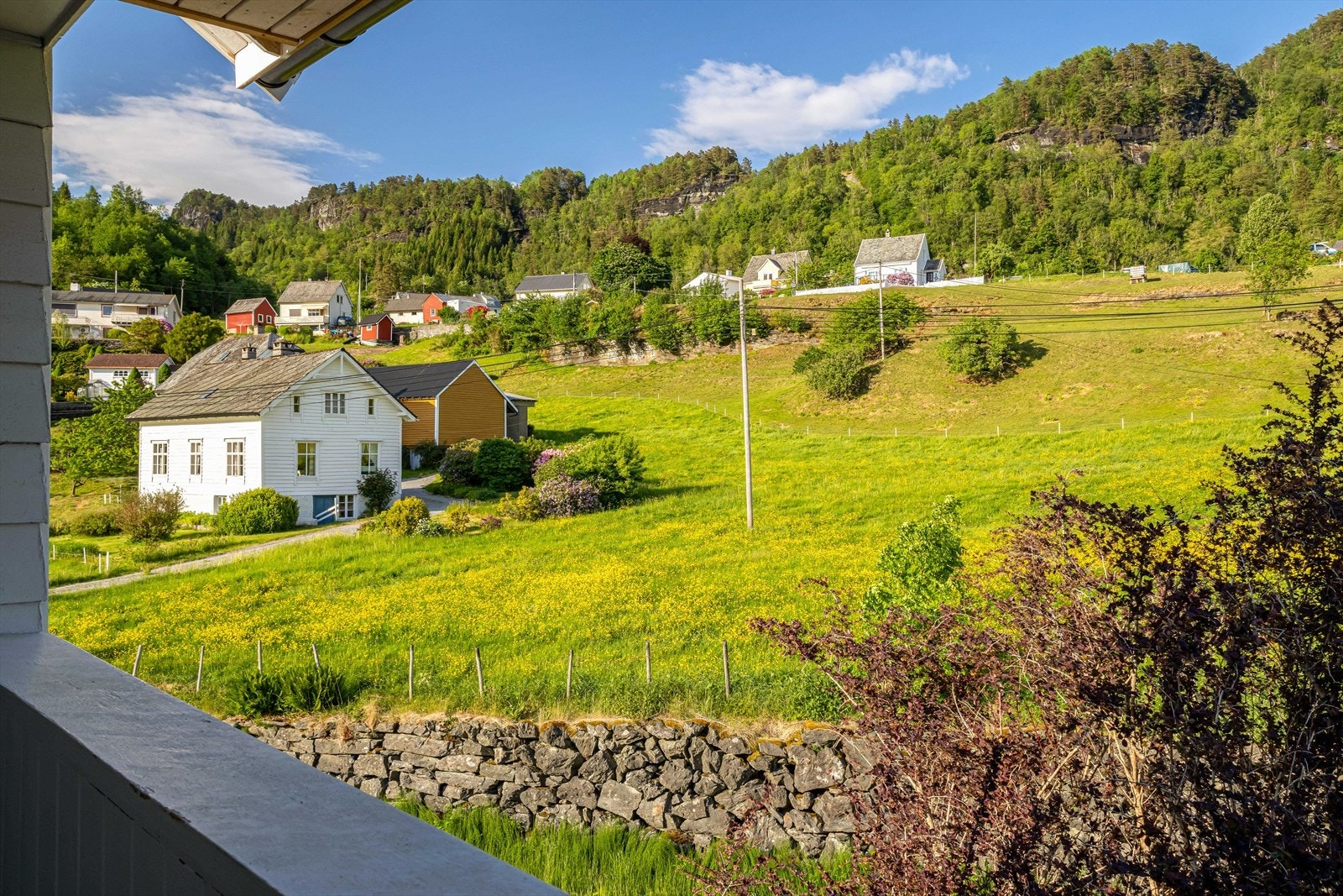 Utgang fra vaskerom til trivelig balkongtørkeplass med utsikt over landlige omgivelser. Heisbare klessnorer som på vaskerommet Galleribilde
