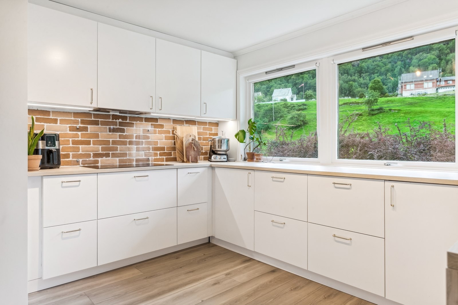 Tidløs kjøkkeninnredning med mye skap- og benkeplass Galleribilde