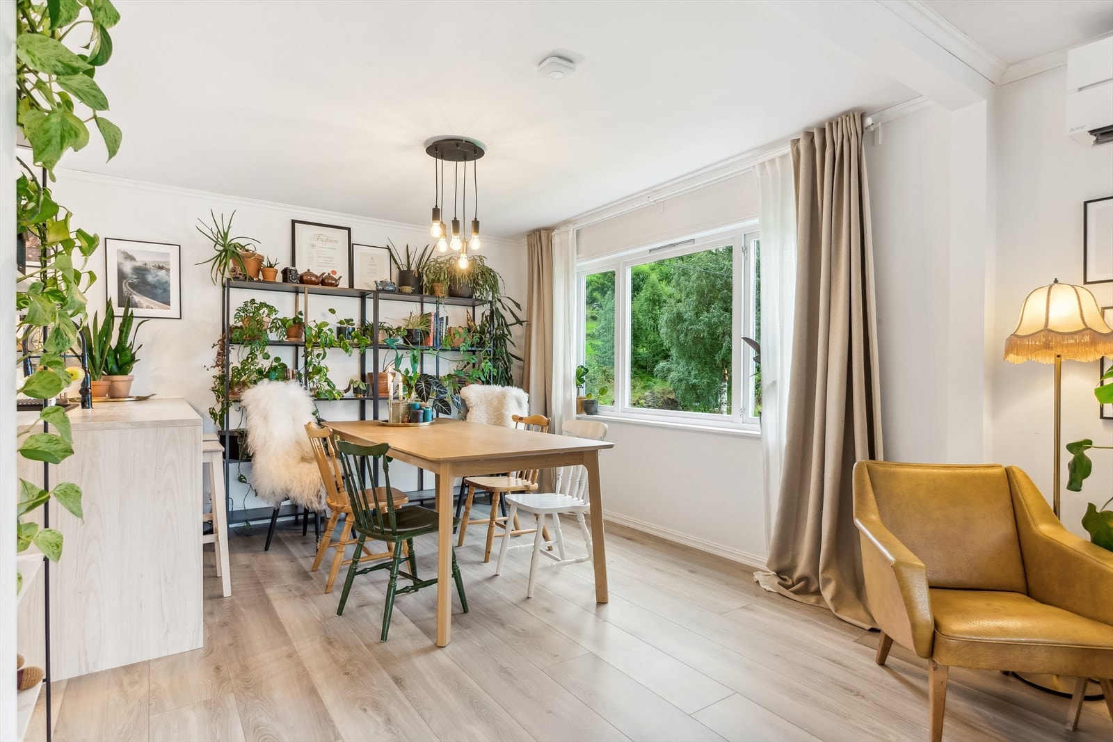 Lys og fin spisestue hvor en får naturlig lys fra spisestue, kjøkken og salongseksjonen Galleribilde