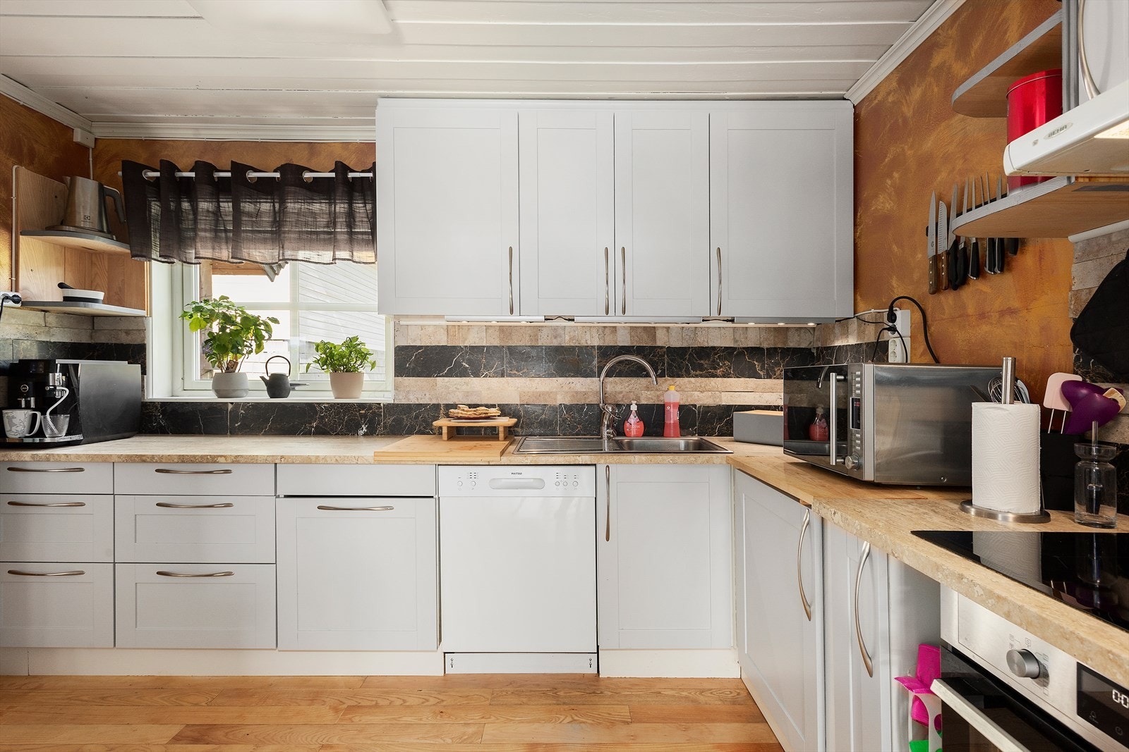 Hvitevarer som induksjonstopp, kjøle/fryse-skap med vann og isbitmaskin, oppvaskmaskin og stekeovn medfølger handelen. Galleribilde