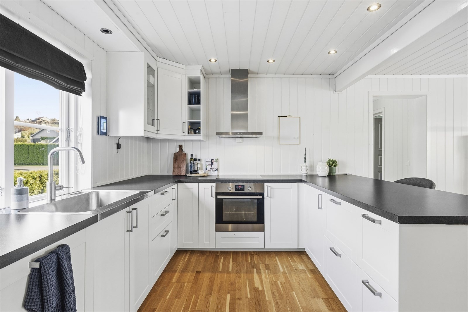 Innbydende kjøkken med hvite profilerte fronter og laminert benkeplate Galleribilde