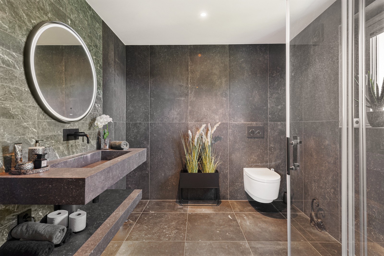 Luksuriøst bad med fliser og vegggeheng Geberit toalett med spyling og tørk funksjon, samt automatisk lokkheving Galleribilde