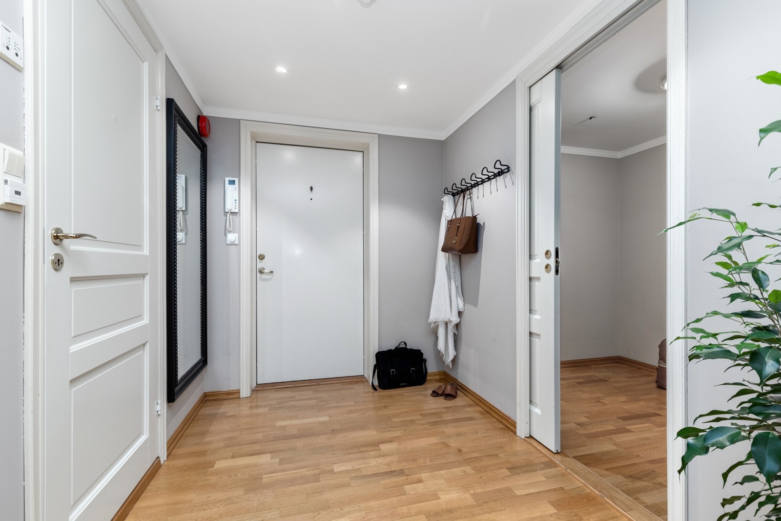 Callinganlegg og plass til å henge av seg klær ved inngangsdøren Galleribilde