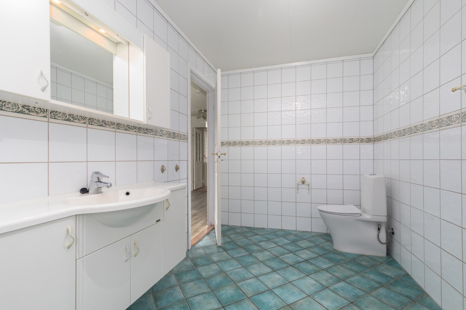 Badet er klassisk innredet med, servant over servant skap med profilert utførelse, toalett og dusjkabinett. Galleribilde