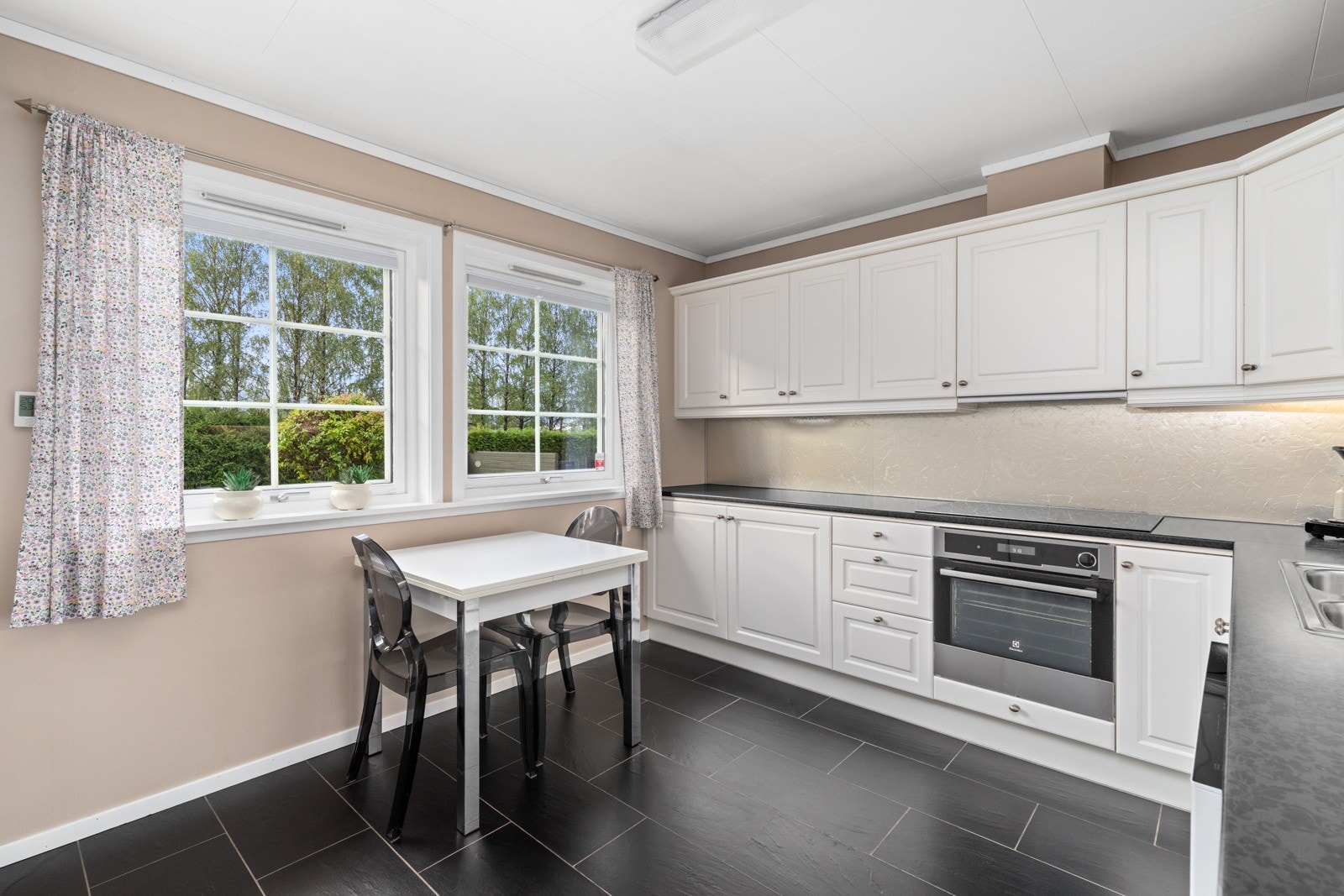 Kjøkkenet har innredning med profilerte fronter. Benkeplaten er av laminat. Galleribilde