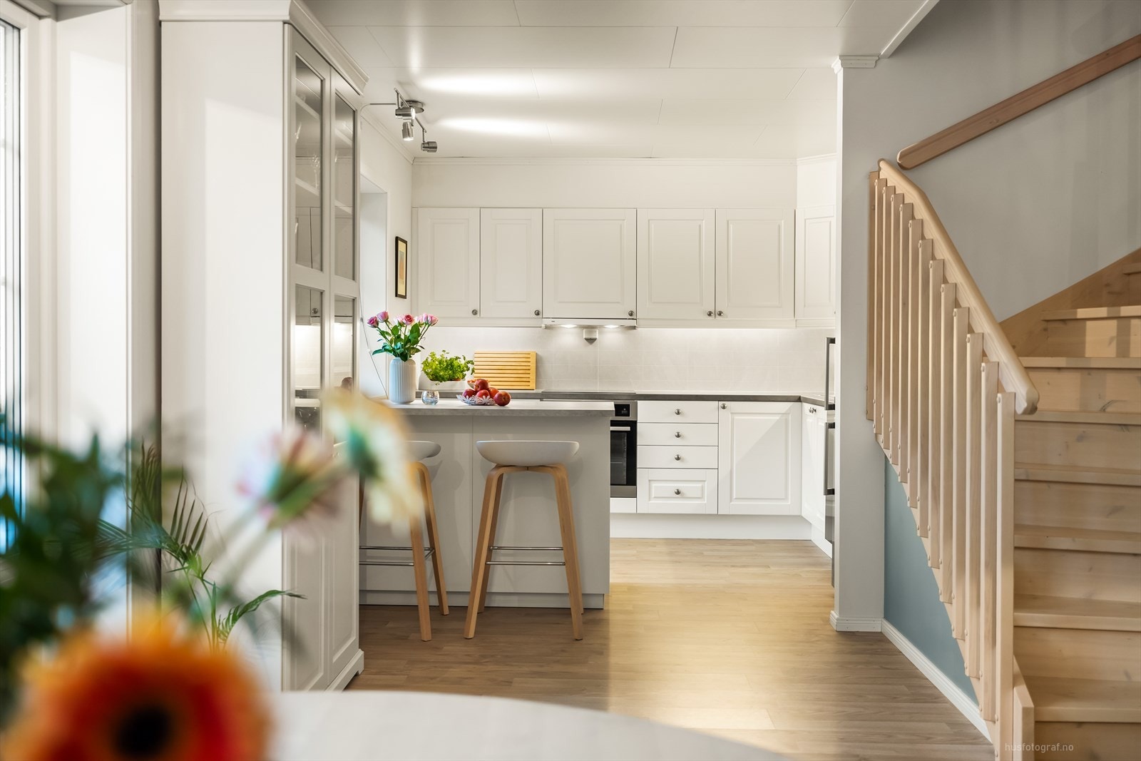 Klassisk kjøkkeninnredning med hvite profilerte fronter og benkeplate av laminat. Galleribilde