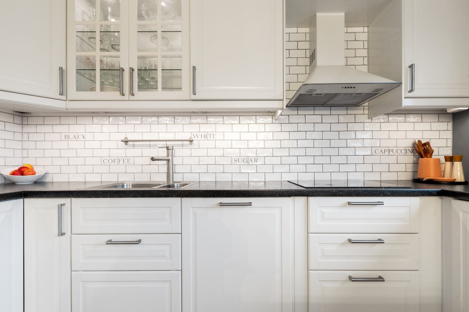 Fine hvite fliser mellom benkeplate og overskap. Galleribilde