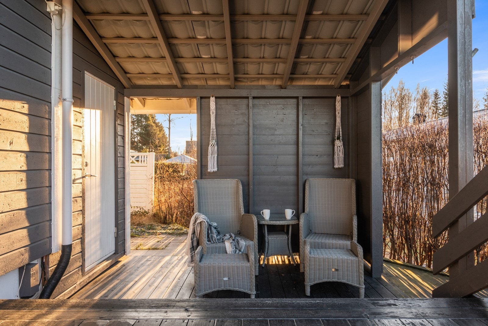 Ute er det en liten og koselig plass med plass for to under tak. Her er det også inngang til en utvendig bod - praktisk! Galleribilde