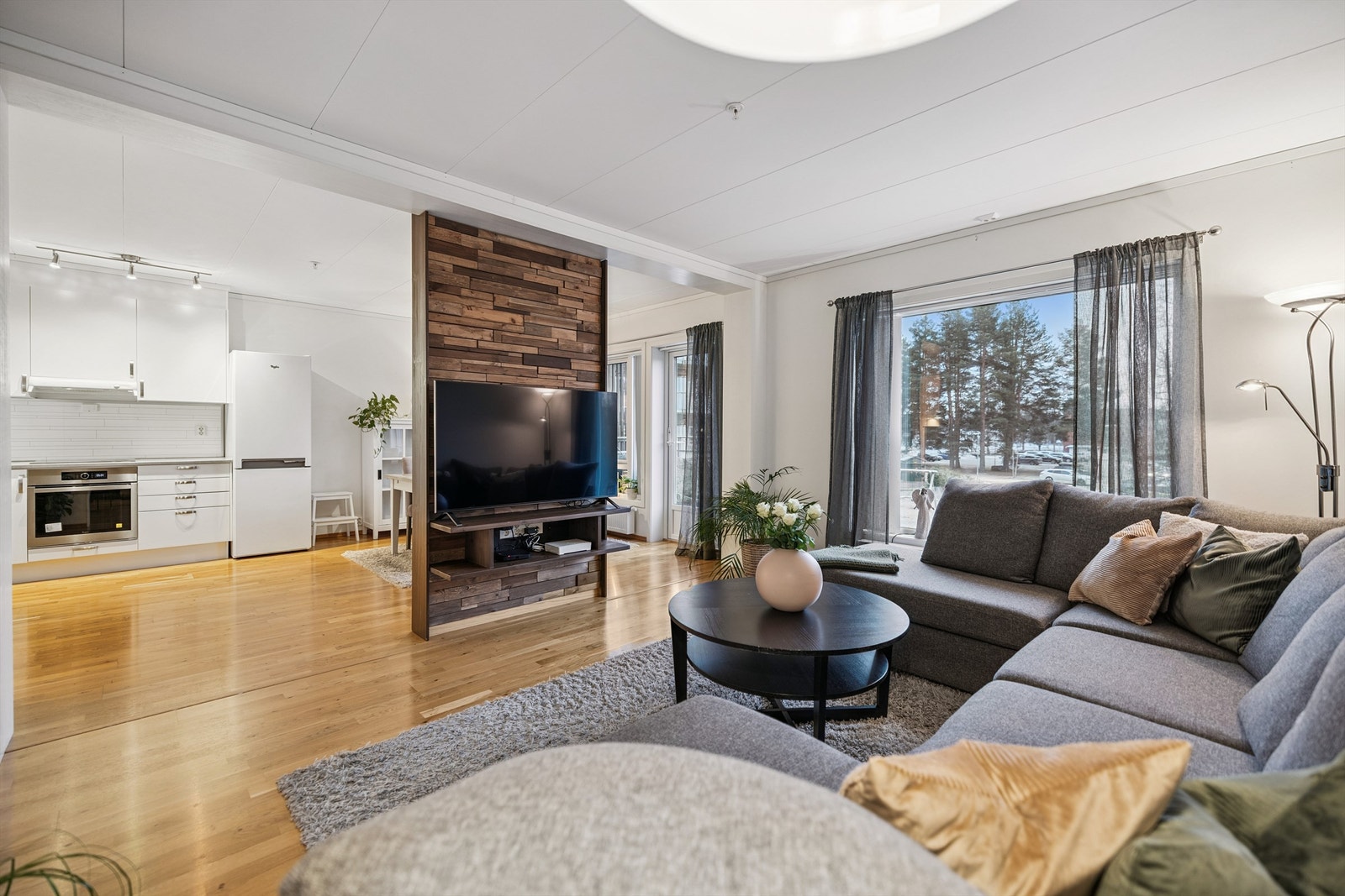 En halvvegg fungerer som en praktisk og stilfull romdeler mellom stue og kjøkken/spisestue. Galleribilde