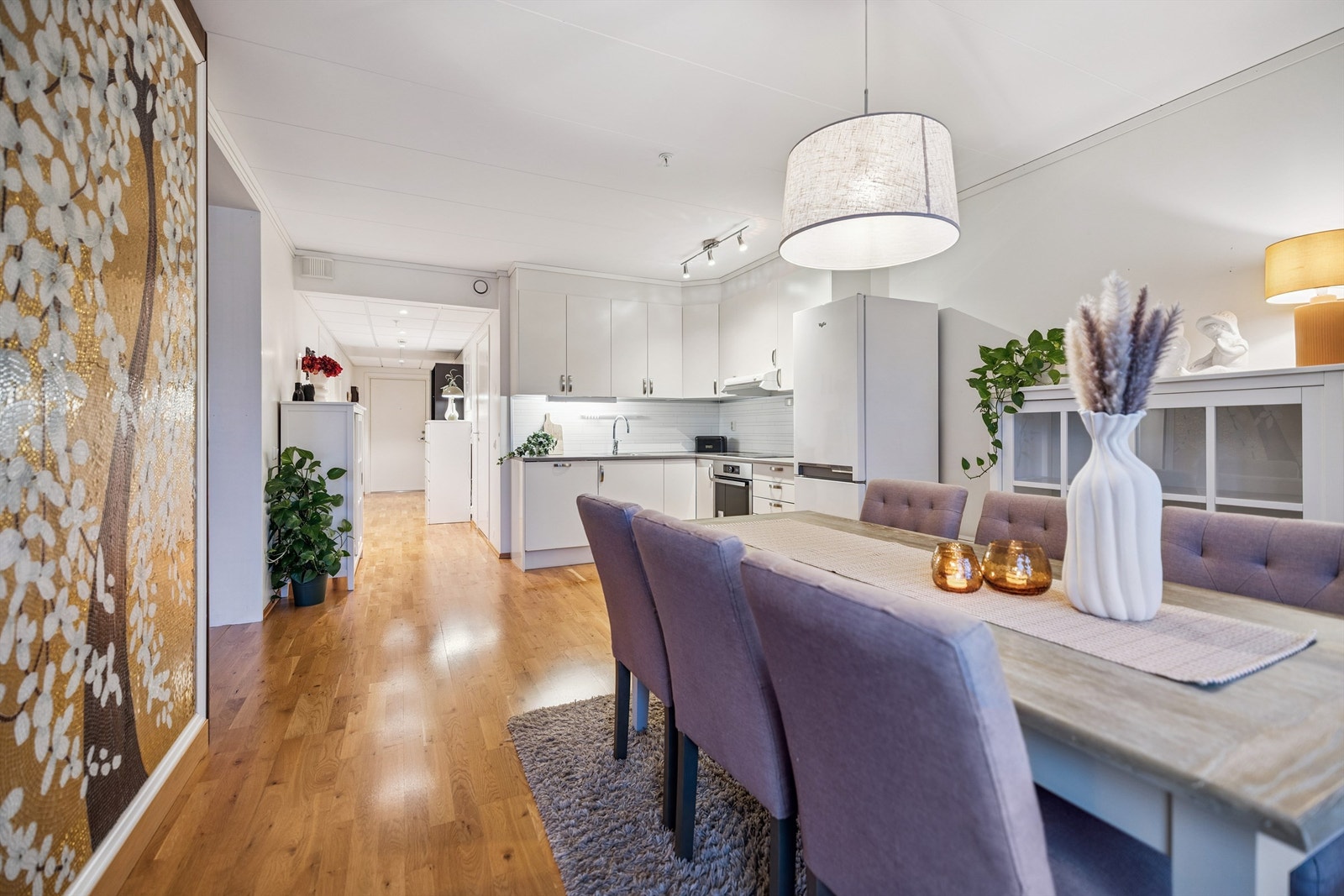 Utsyn fra stuen mot kjøkkenet og gangen, som illustrerer den gode romfølelsen. Galleribilde