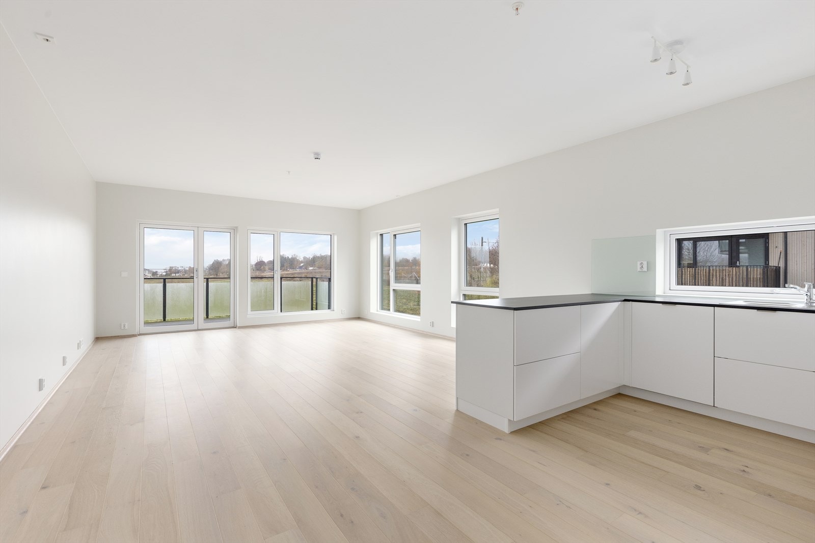 Stua og kjøkkenet har en harmonisk og innbydende atmosfære, med lyse overflater og åpen sosial løsning. Galleribilde