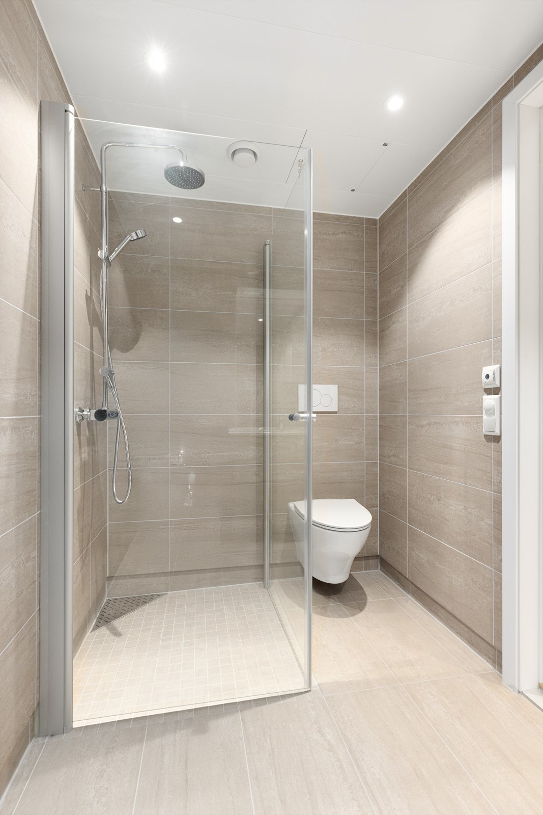 Begge bad har dusjhjørne med glassvegger og eksklusiv regnfallsdusj, samt veggmontert toalett. Galleribilde