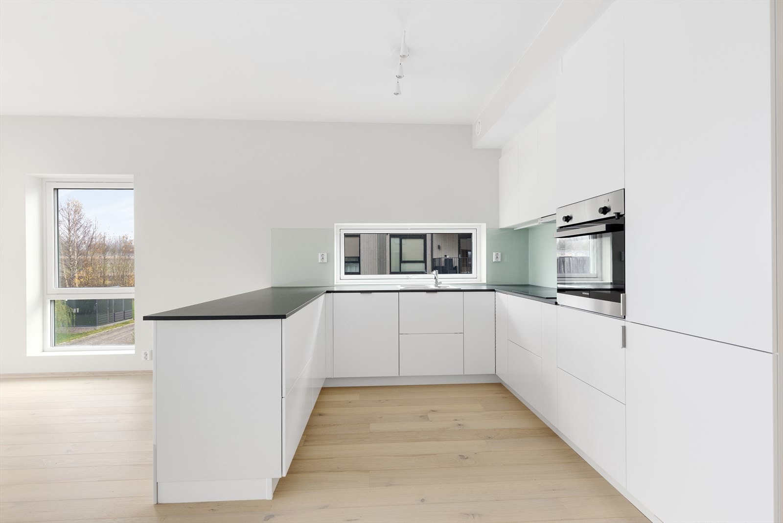 Som et naturlig skille mot stua er det etablert kjøkkenøy med oppbevaringsplass og gode arbeidsflater. Kjøkkenet har integrerte hvitevarer som oppvaskmaskin, platetopp, stekeovn og kjøl/fryseskap. Galleribilde