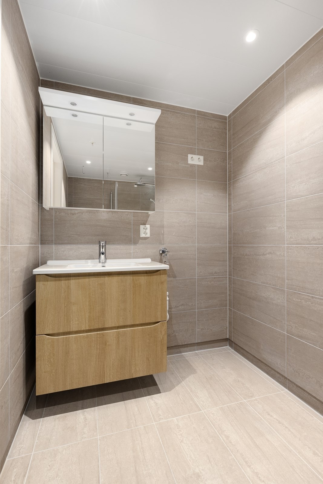 Innredning med skuffer og heldekkende servant, samt ytterligere oppbevaringsplass i speilskap. Galleribilde