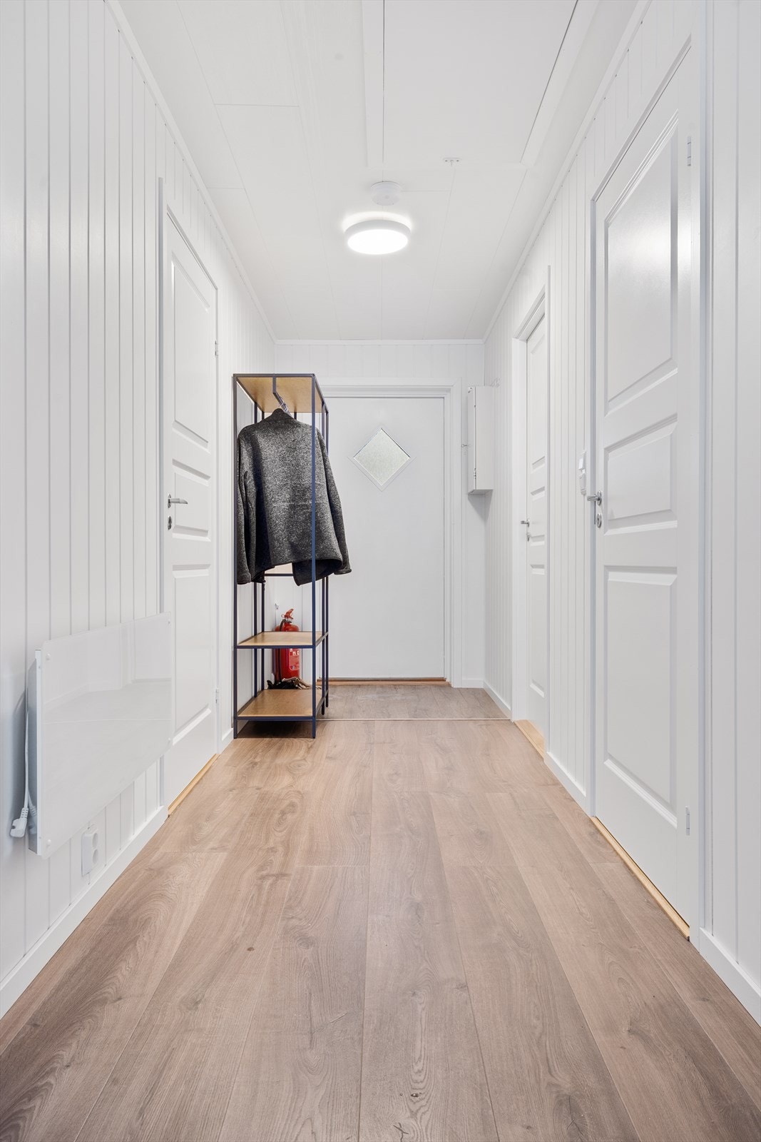 Lys og pen gang med plass for oppheng av yttertøy. Galleribilde