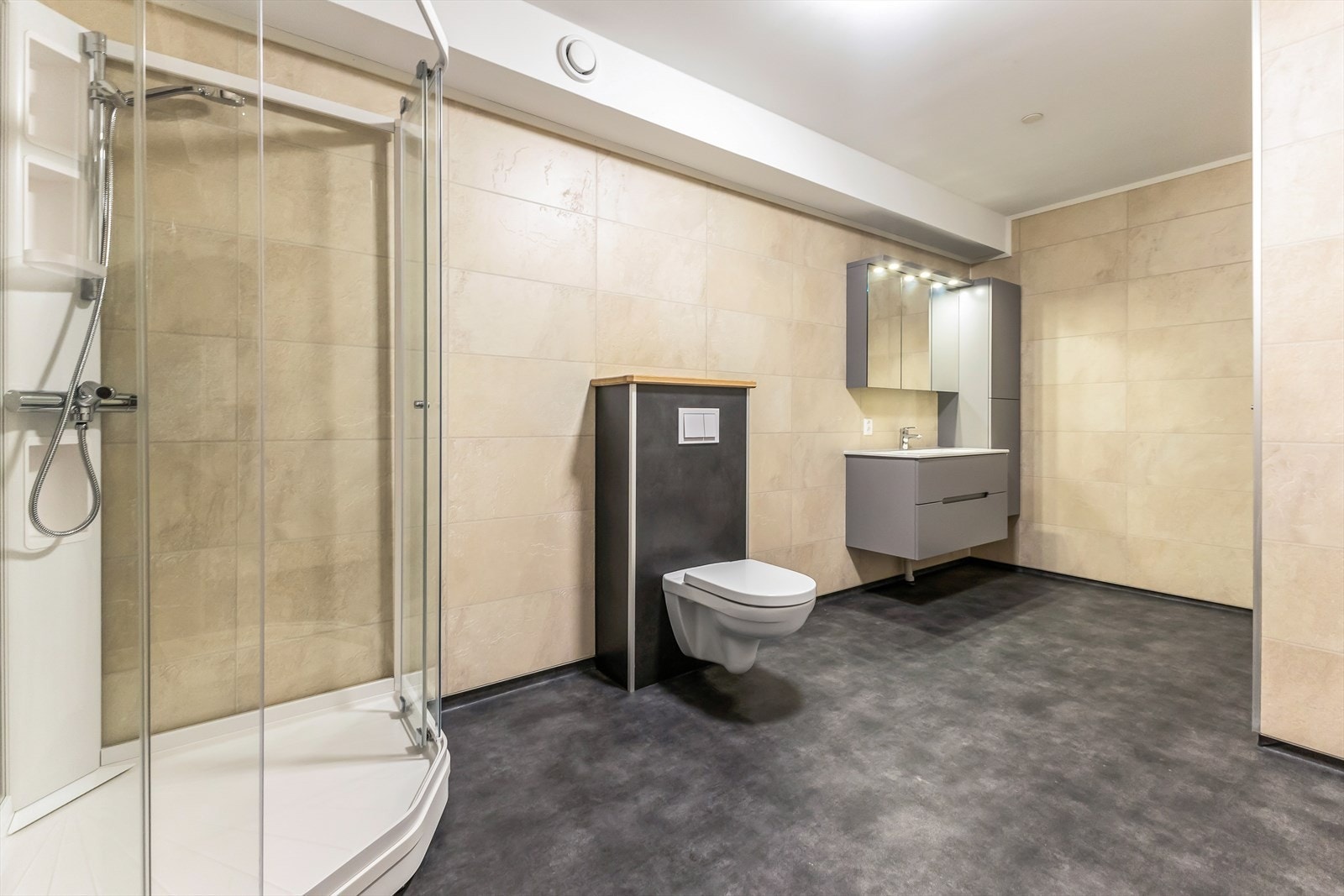 Stort dusjkabinett fra annerkjent leverandør. Vegghengt wc med trykkbetjening. Praktisk, pen baderomsinnredning med både store skuffer, speilskap og sideskap. Galleribilde