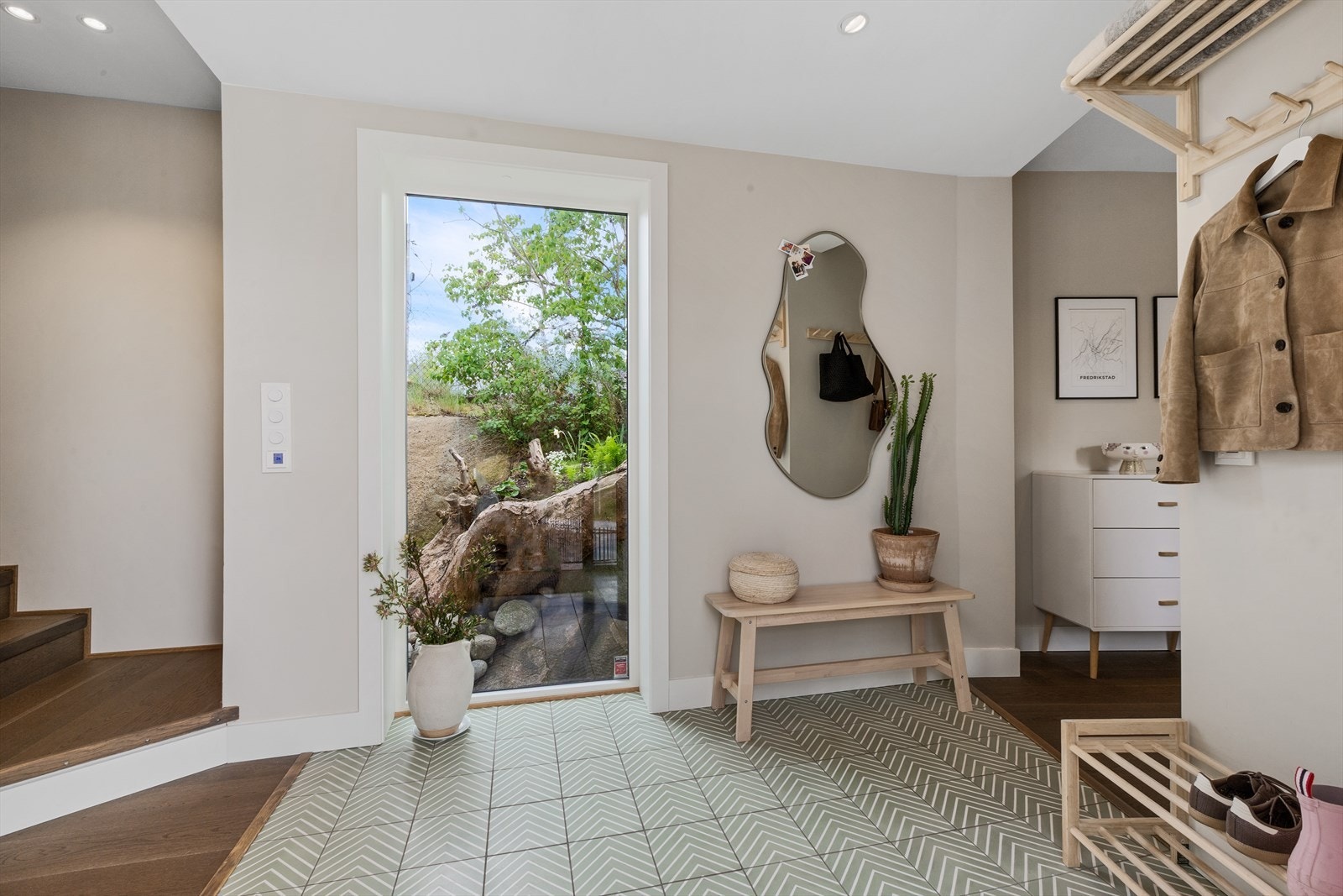 Entreen har flotte fliser i gulv og stort vindu som byr naturen inn i rommet Galleribilde