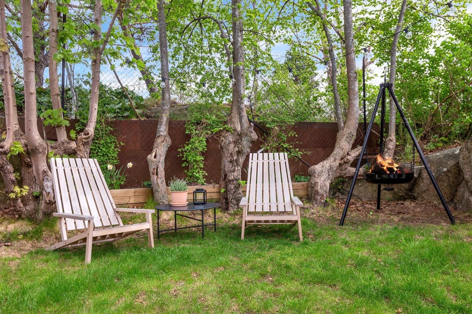 Skjermet sitteområde under trekronene med bålpanne, et koselig hjørne for rolige kvelder. Galleribilde