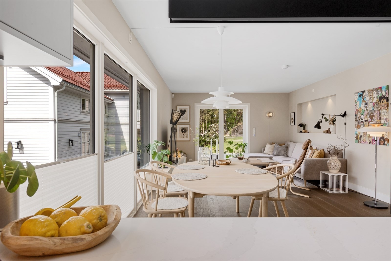 Lys spiseplass med store skyvedører mot uteområde. Harmoniske farger og plass til familie eller gjester rundt bordet. Galleribilde