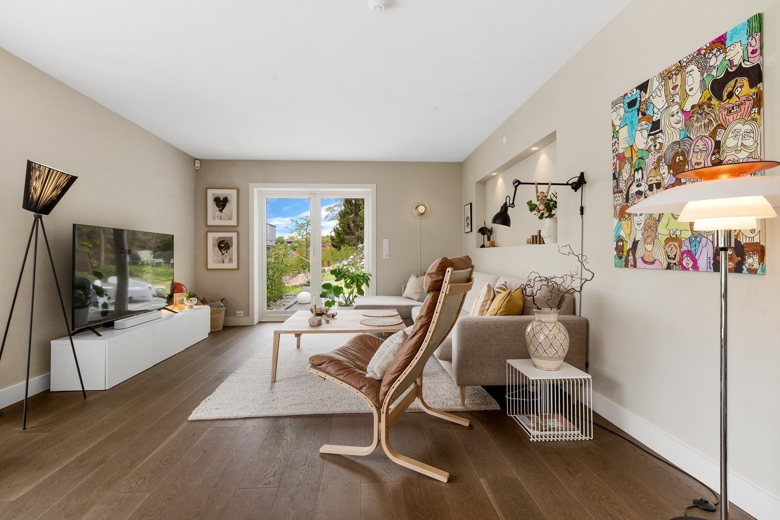 Lun stuedel med utgang til hage, integrert nisje med belysning og gjennomført interiør i varme toner. Galleribilde