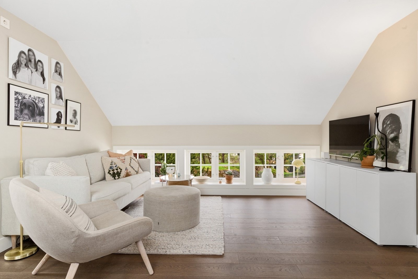 Loftstue med lavtliggende vindusrekke som gir utsyn mot hagen og slipper inn rikelig med lys. Stilren innredning og behagelig atmosfære. Galleribilde