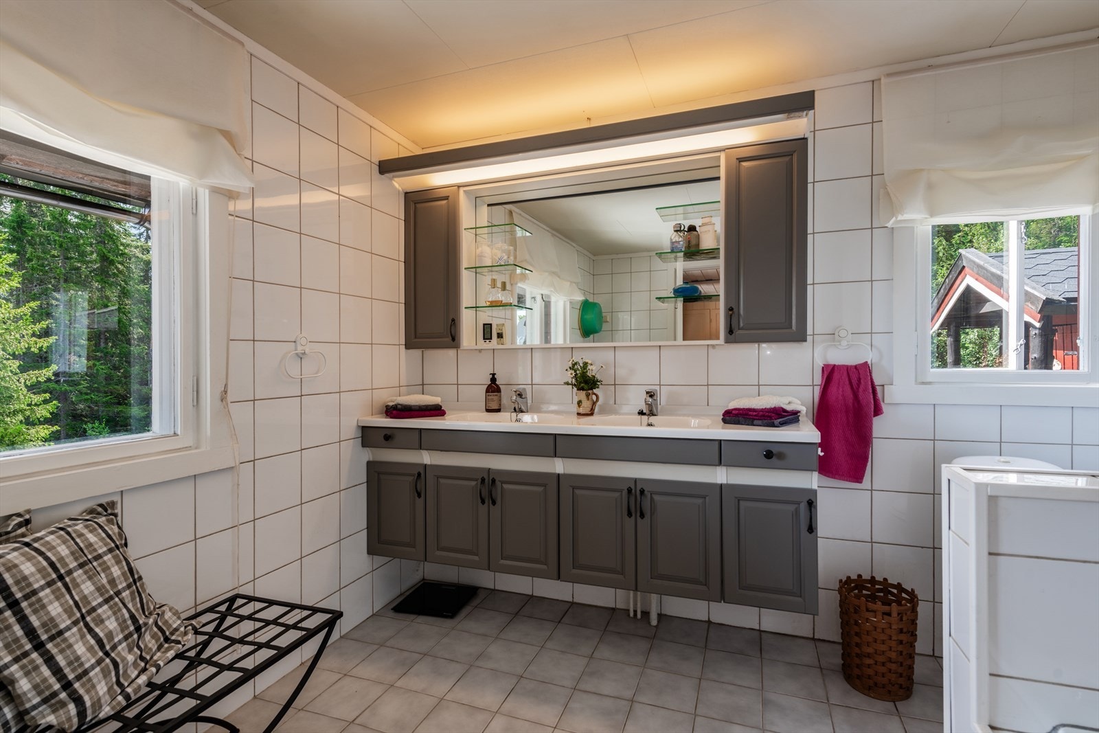 Stort flislagt bad med innredning og to servanter, toalett og badekar med dusj, samt opplegg for vaskemaskin. Galleribilde