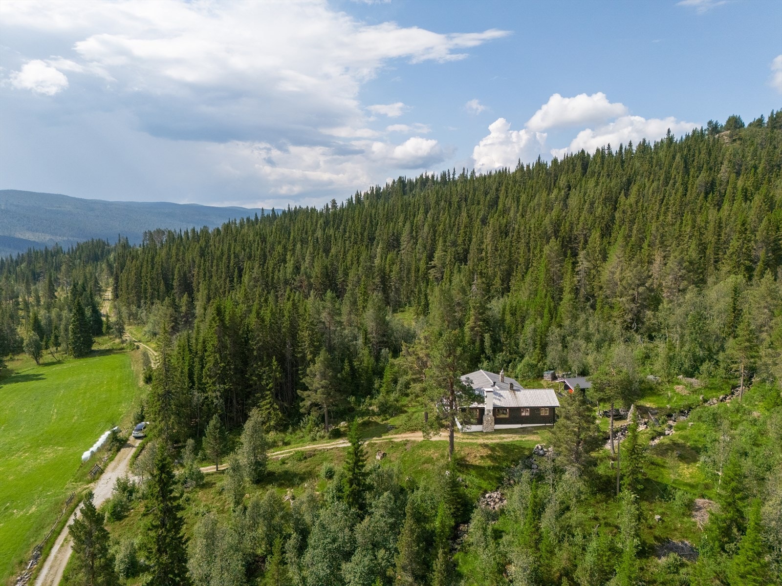Eiendommen er idyllisk plassert ved skogkanten, omkranset av frodig natur og vakker utsikt. Perfekt for naturopplevelser og rekreasjon. Galleribilde