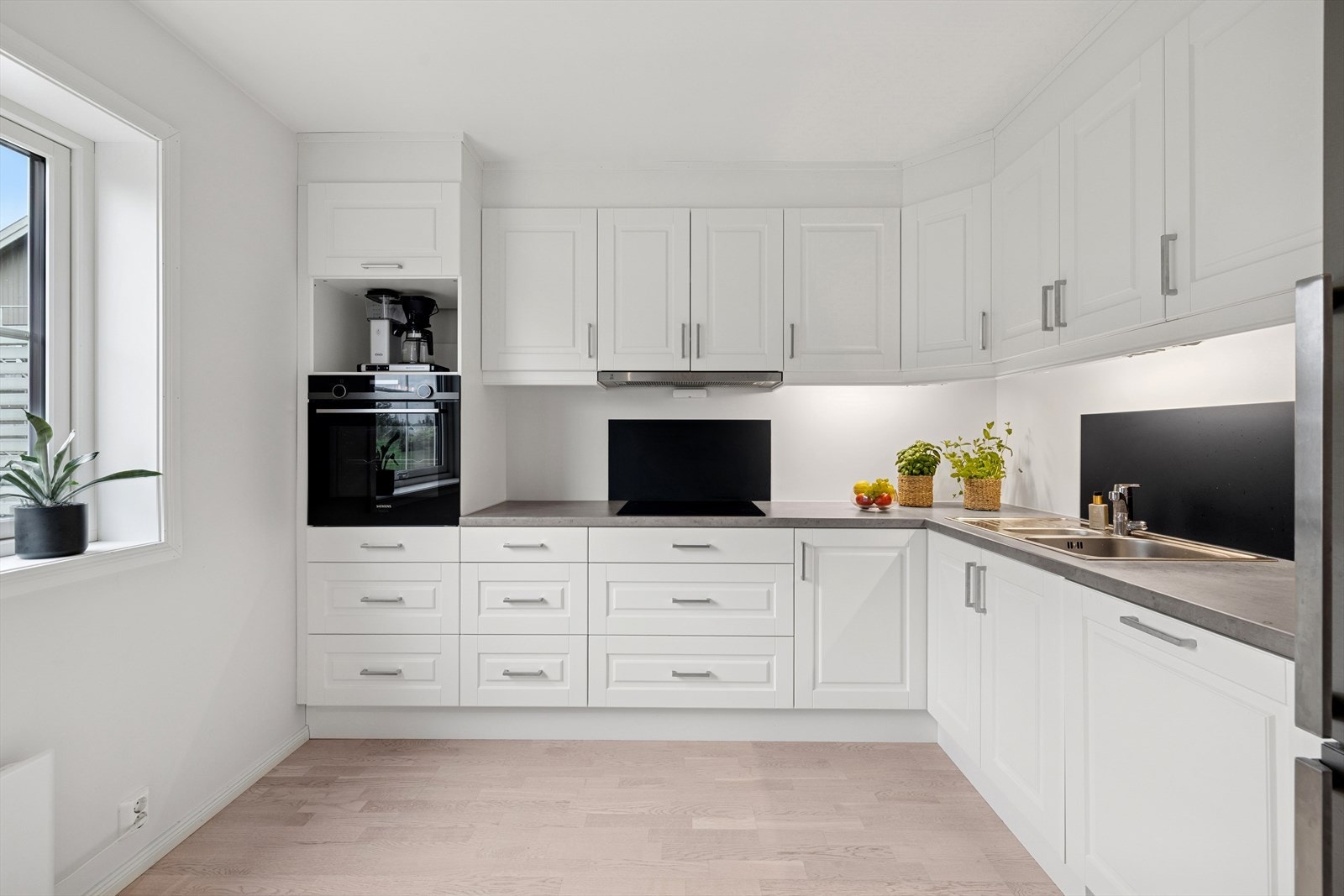 Pen hvit kjøkkeninnredning med profilerte fronter og laminat benkeplate Galleribilde