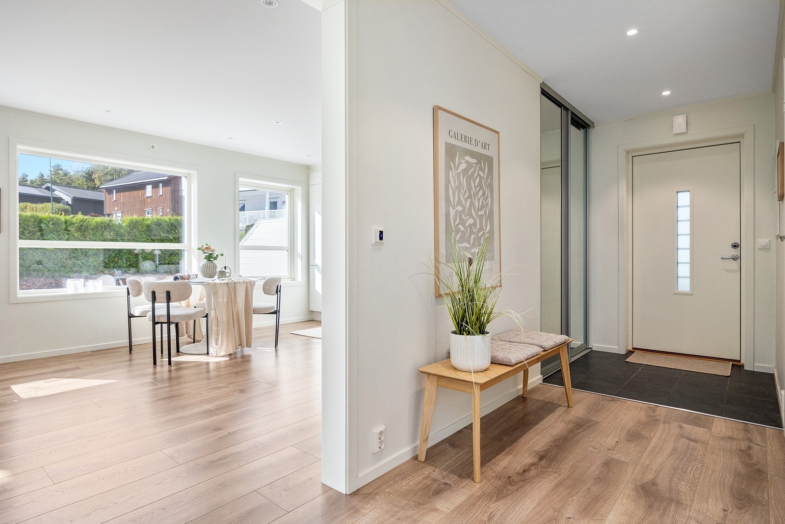 Det er en lys og trivelig entre med skyvedørsgarderobe Galleribilde