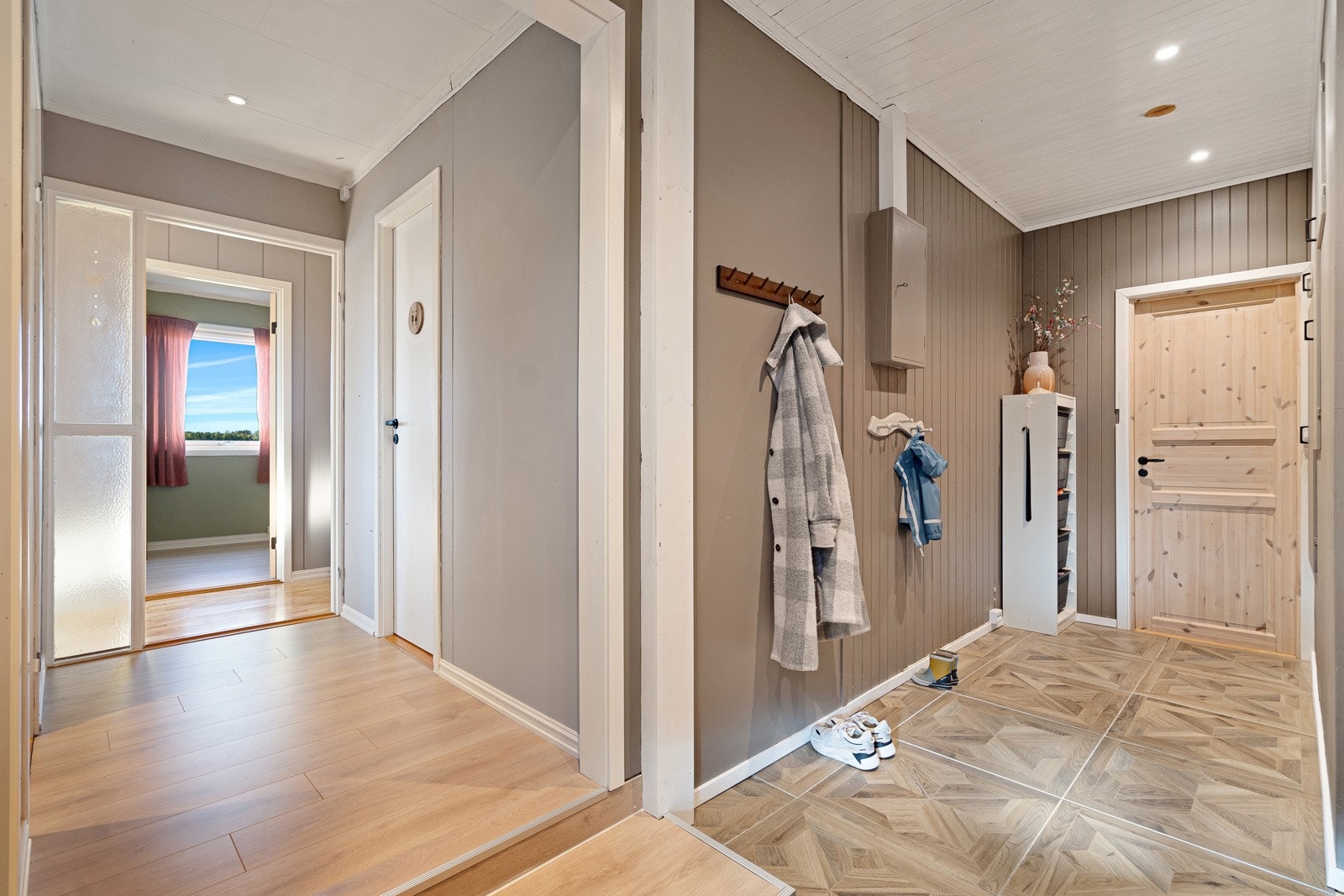 Det er videre inngang til vaskerommet fra gangen, samt dør til kjellernedgangen. Videre kommer man inn til hoveddelen av boligen. Galleribilde