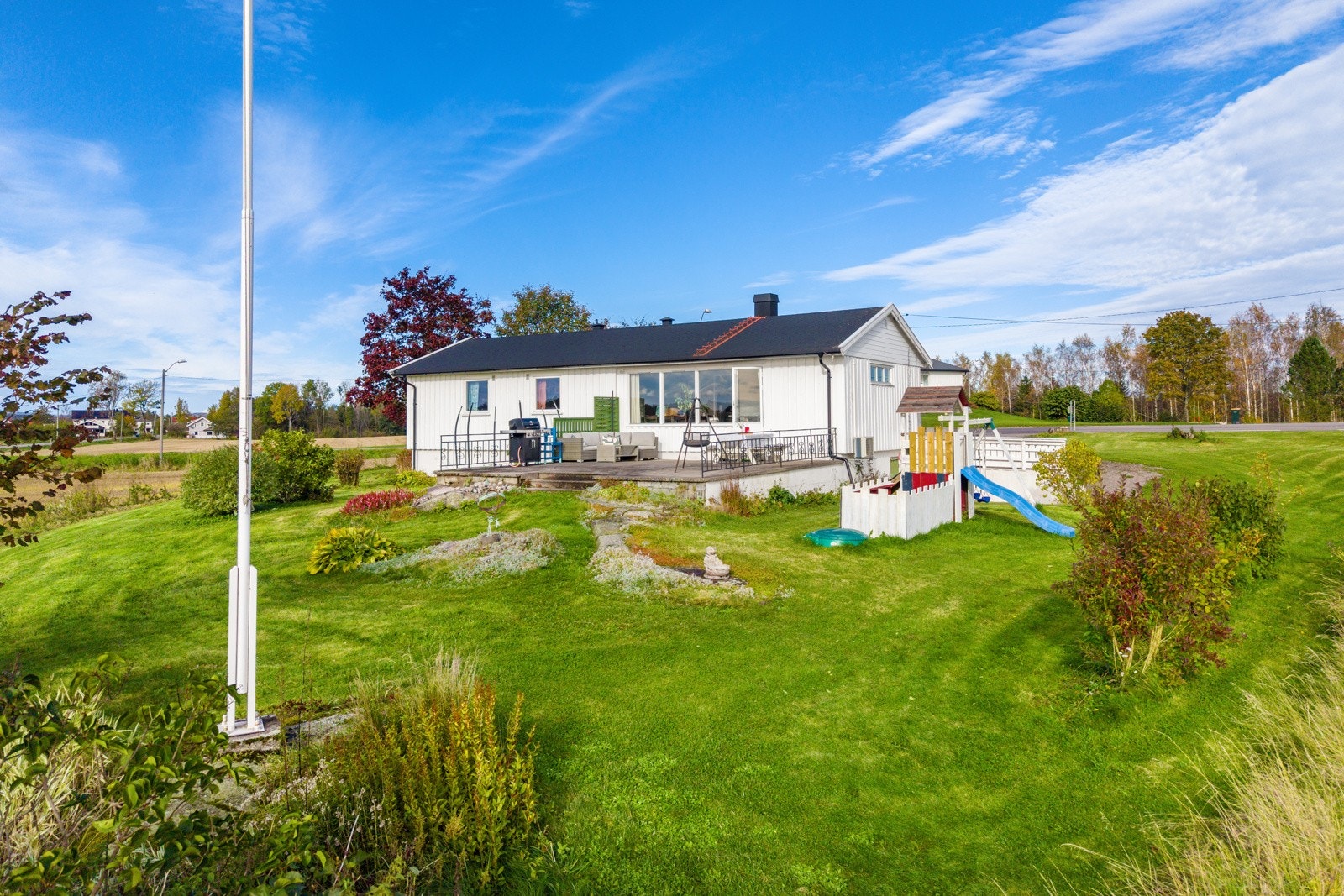 Romslig hagetomt med flaggstang Galleribilde