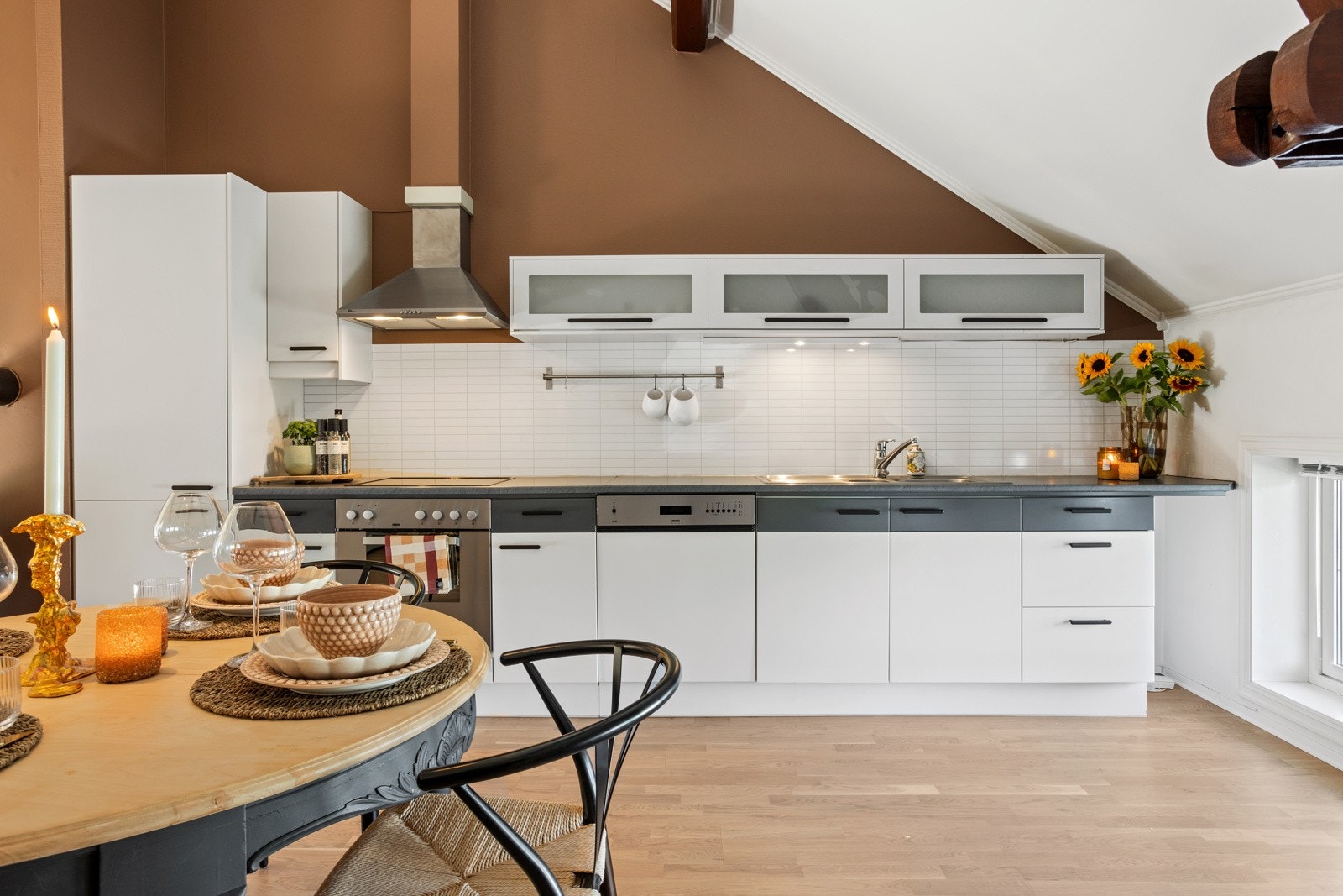 Kjøkkeninnredning langs den ene veggen i rommet. Vinduer slipper inn naturlig lys. Galleribilde