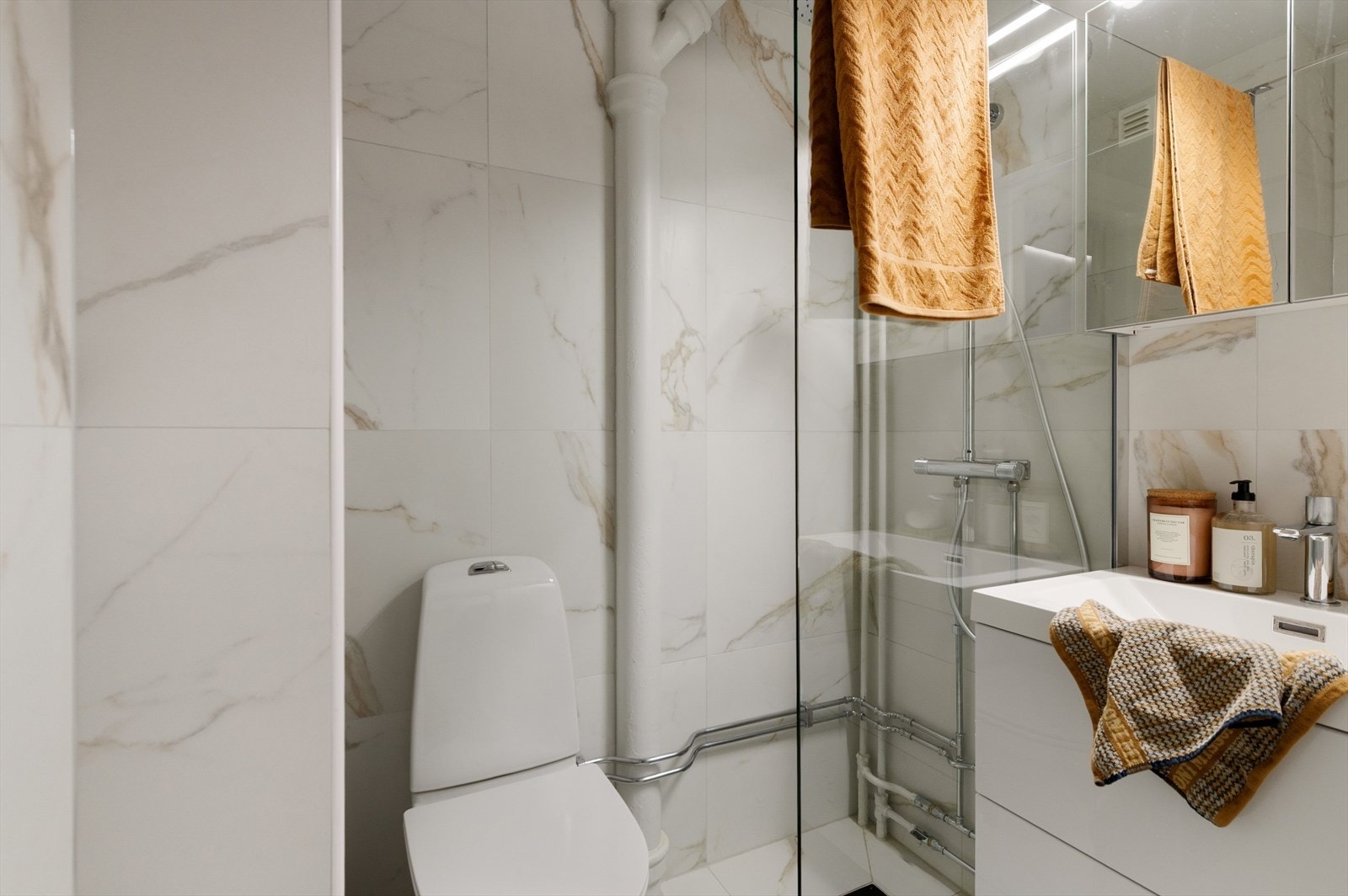 Helfliset bad med lys innredning, toalett og dusjhjørne. Galleribilde