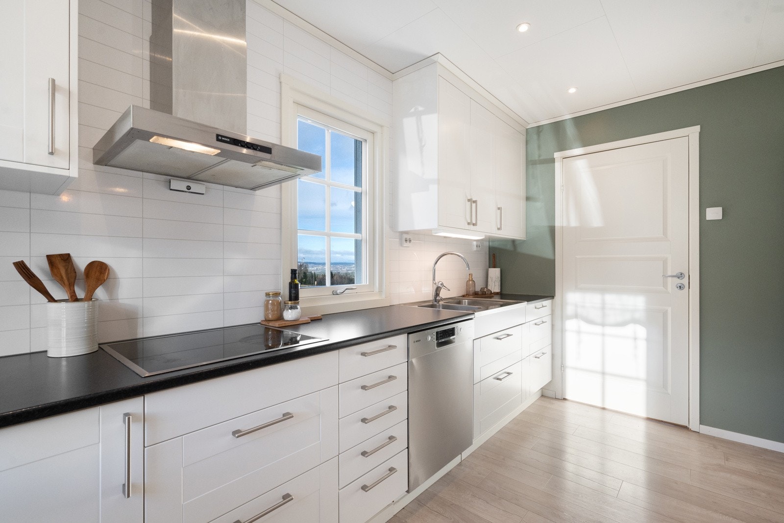 Her er det plass til alle frittstående hvitevarer. Flislaminat over benk gir både et pent uttrykk og enkel vedlikehold. Galleribilde