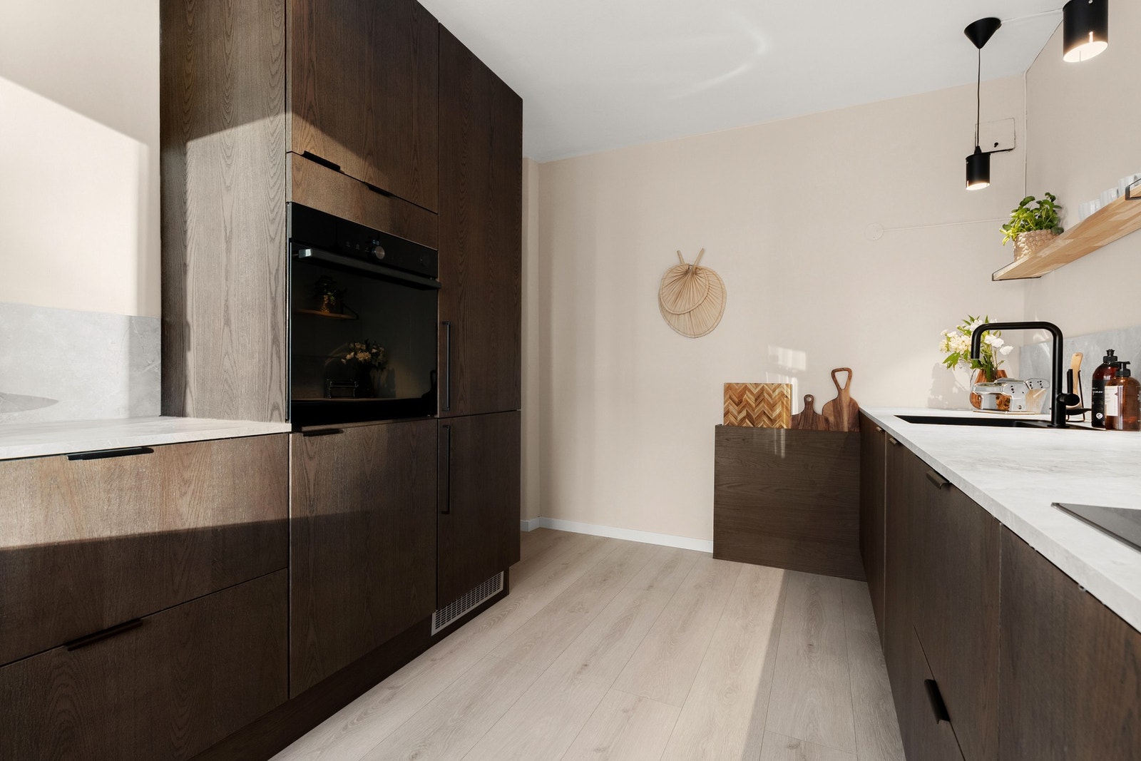Lekker kjøkkenløsning fra DESIGNA med eik finér og toppmoderne hvitevarer - dampovn, pirolyse og AEG-platetopp med integrert ventilator. Galleribilde