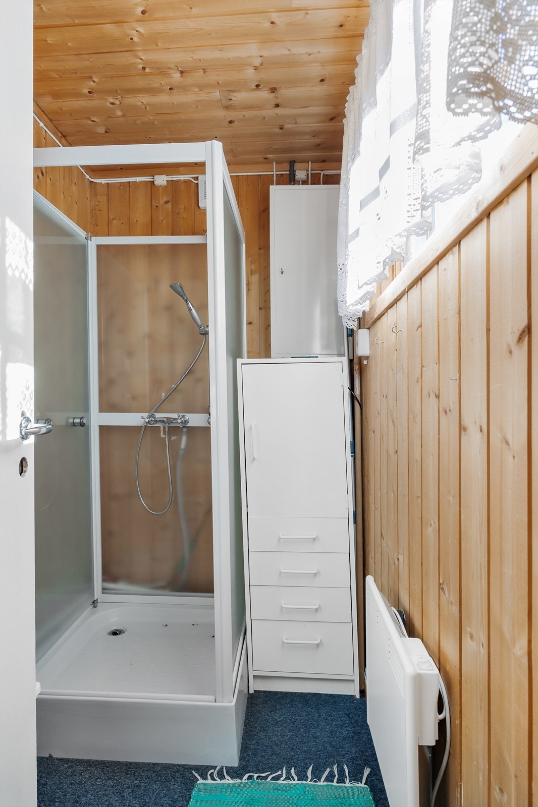 Dusjrommet inneholder en innredning med vask, speil og dusjkabinett. Galleribilde