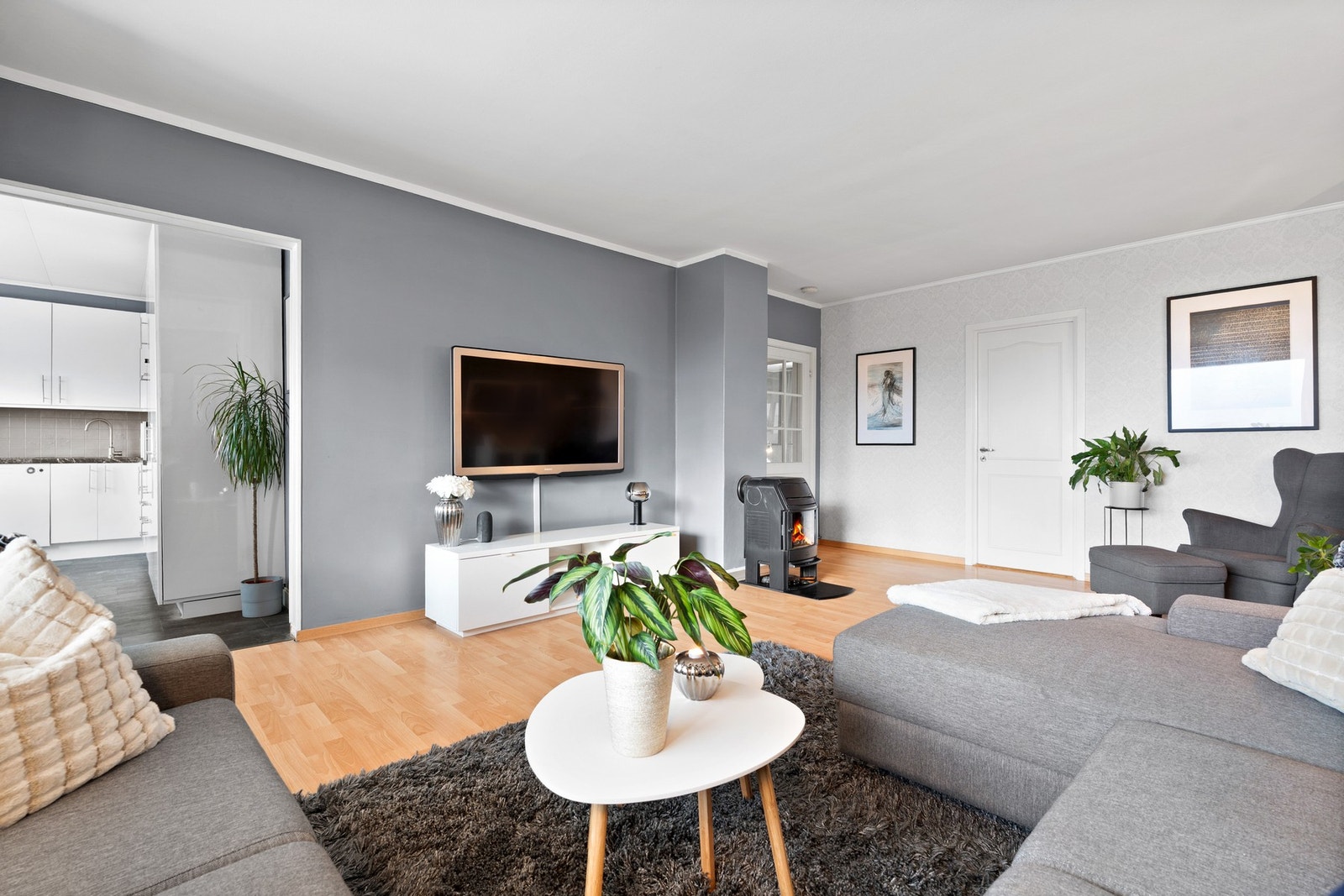 Leiligheten har en praktisk planløsning som gir rom for flere møbleringsmuligheter, og det er god plass til både sofa og en behagelig lenestol. Galleribilde