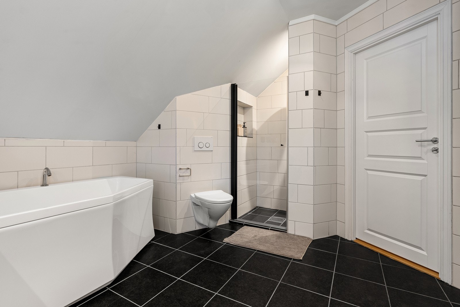 Flislagt og romslig baderom i 2.etasje med dusj og badekar.