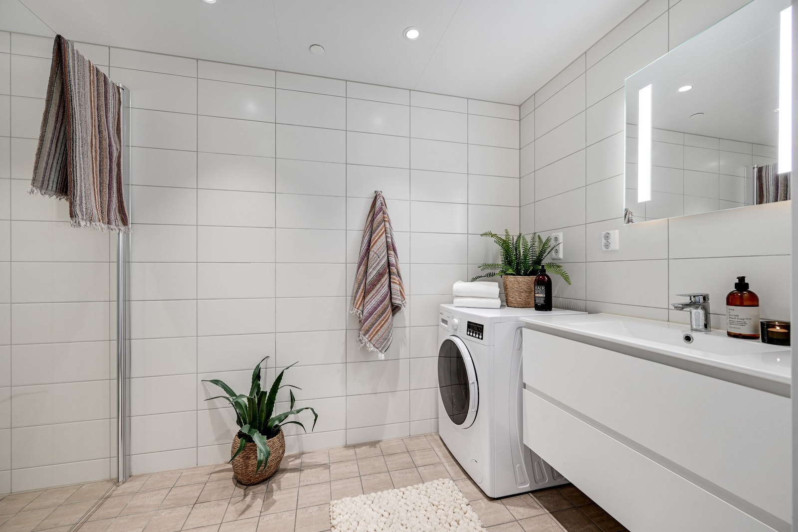 Lyst og flislagt bad med gulvvarme og downlights i himling. Galleribilde