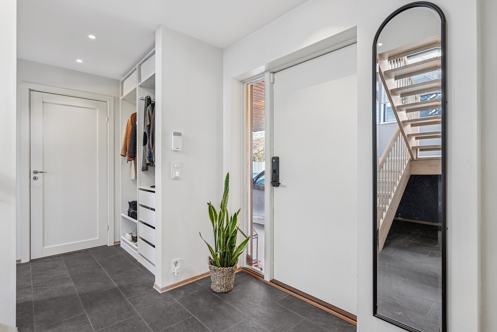 Man kommer inn hall med flislagt gulv og garderobeløsning Galleribilde