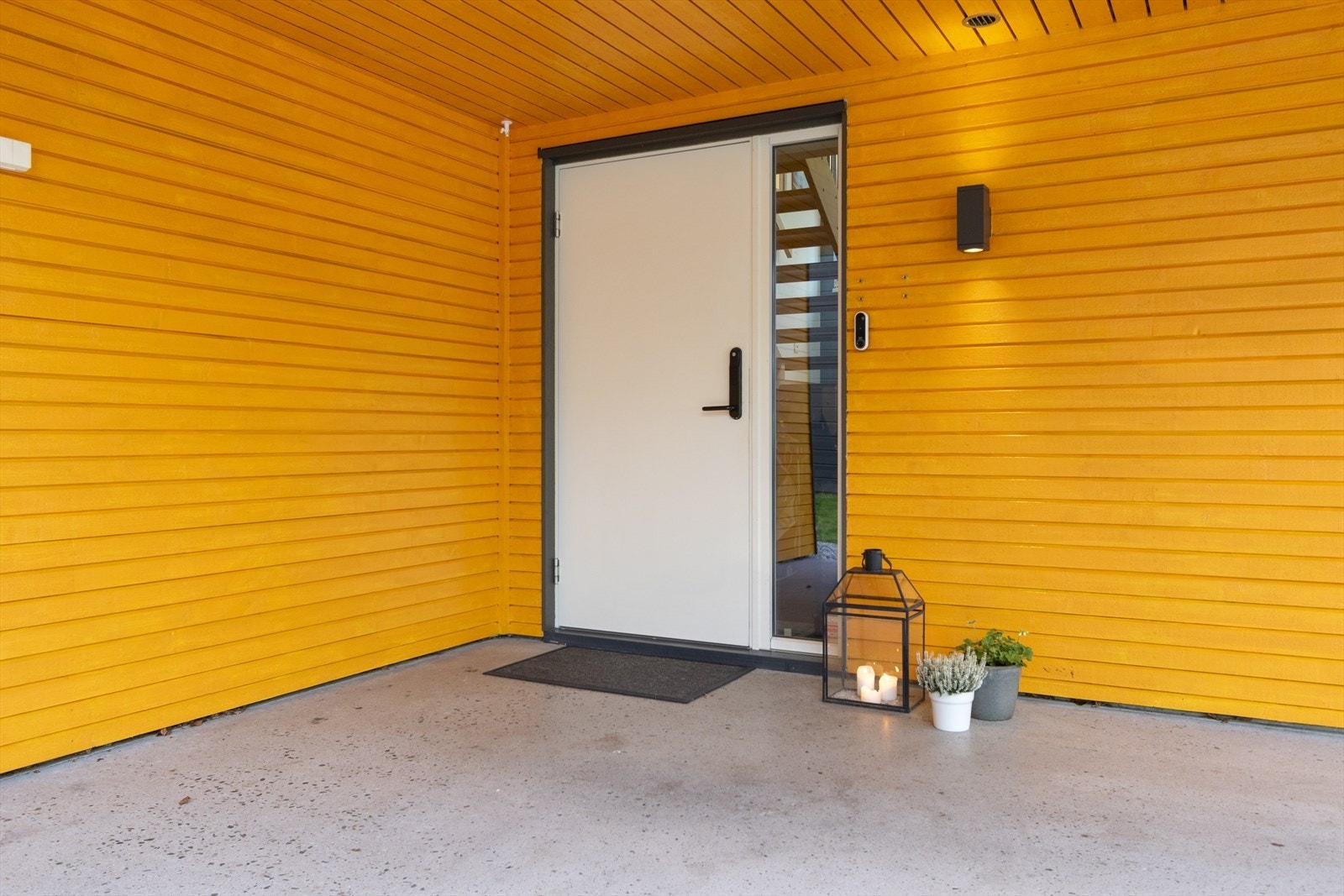 Overbygget inngangsparti med stilrent dekke i slipt betong Galleribilde