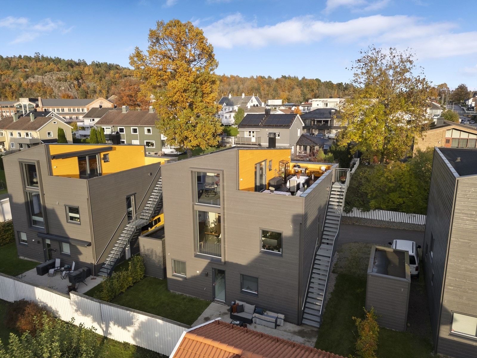 Boligen har pen beplantning og plen - i tillegg til en ekstra uteplass i slipt betong på bakkeplan Galleribilde
