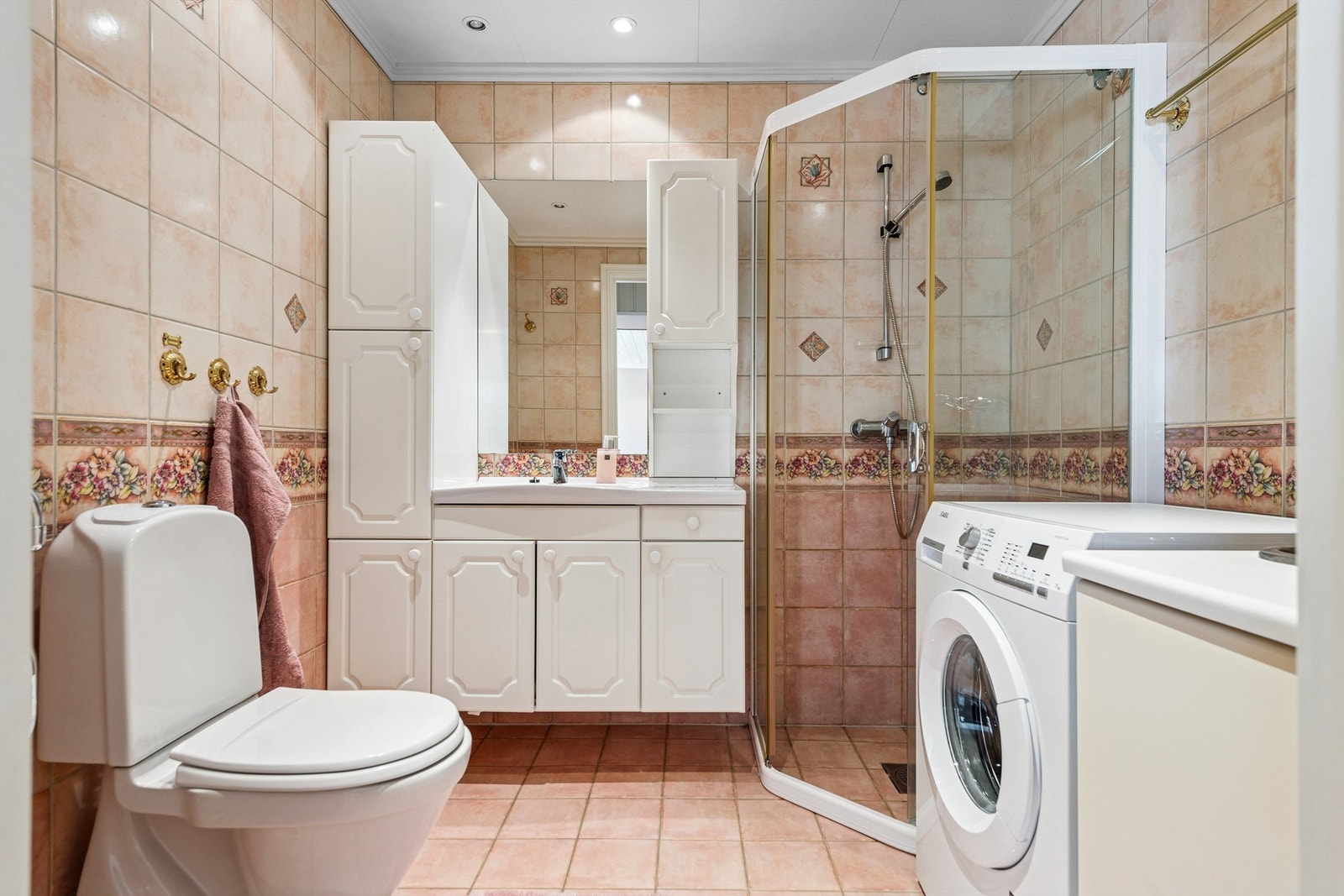 Badet i leiligheten er flislagt, har gulvvarme og opplegg for vaskemaskin. Galleribilde