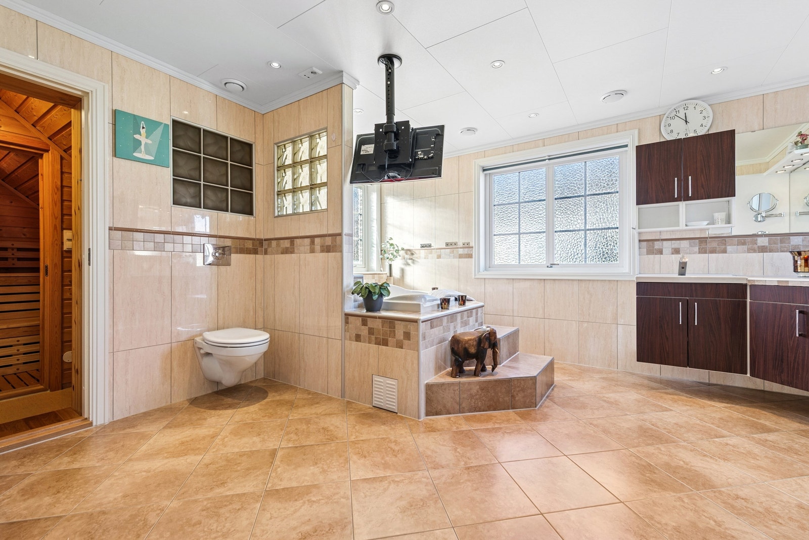 Stort, flislagt bad med både innmurt badekar og egen badstue for velvære. Galleribilde