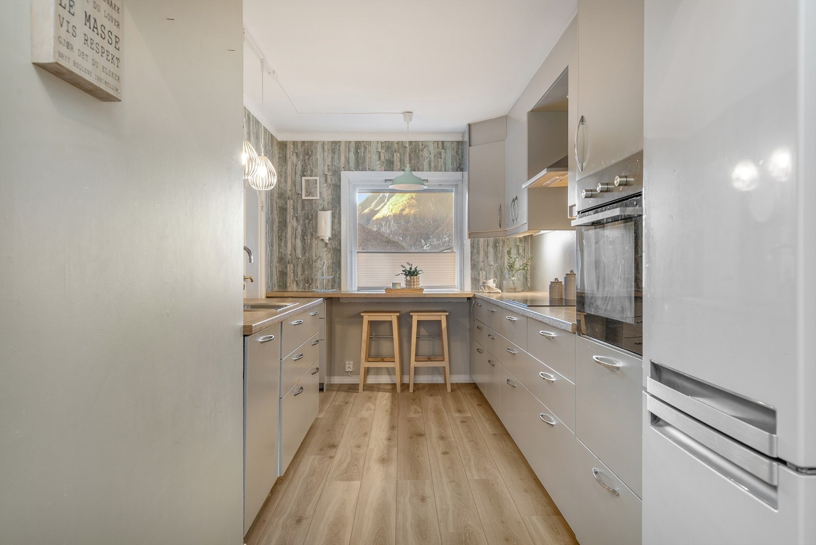 Moderne adskilt kjøkken frå 2017 med glatte, grå frontar og laminat benkeplate. Galleribilde