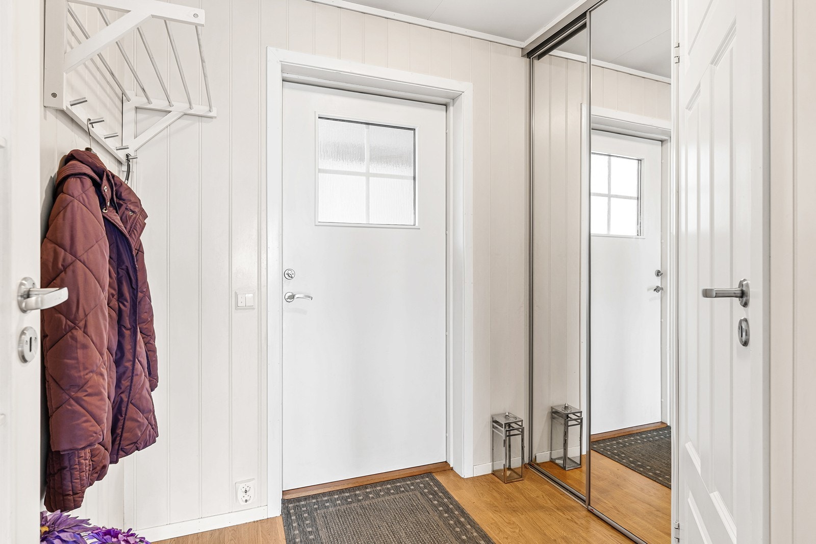 Velkommen inn i en lys og trivelig entré med god plass til sko og yttertøy, enten på knaggrekken eller i den praktiske skyvedørsgarderoben. Galleribilde