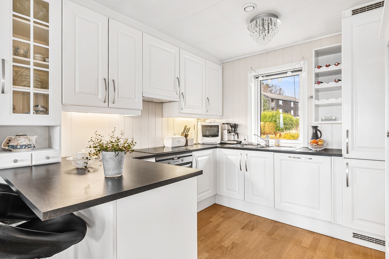 Kjøkkenet er utstyrt med integrert platetopp, stekeovn, oppvaskmaskin og kjøl/frys. Videre er det fine detaljer som vitrineskap og vinhylle. Galleribilde