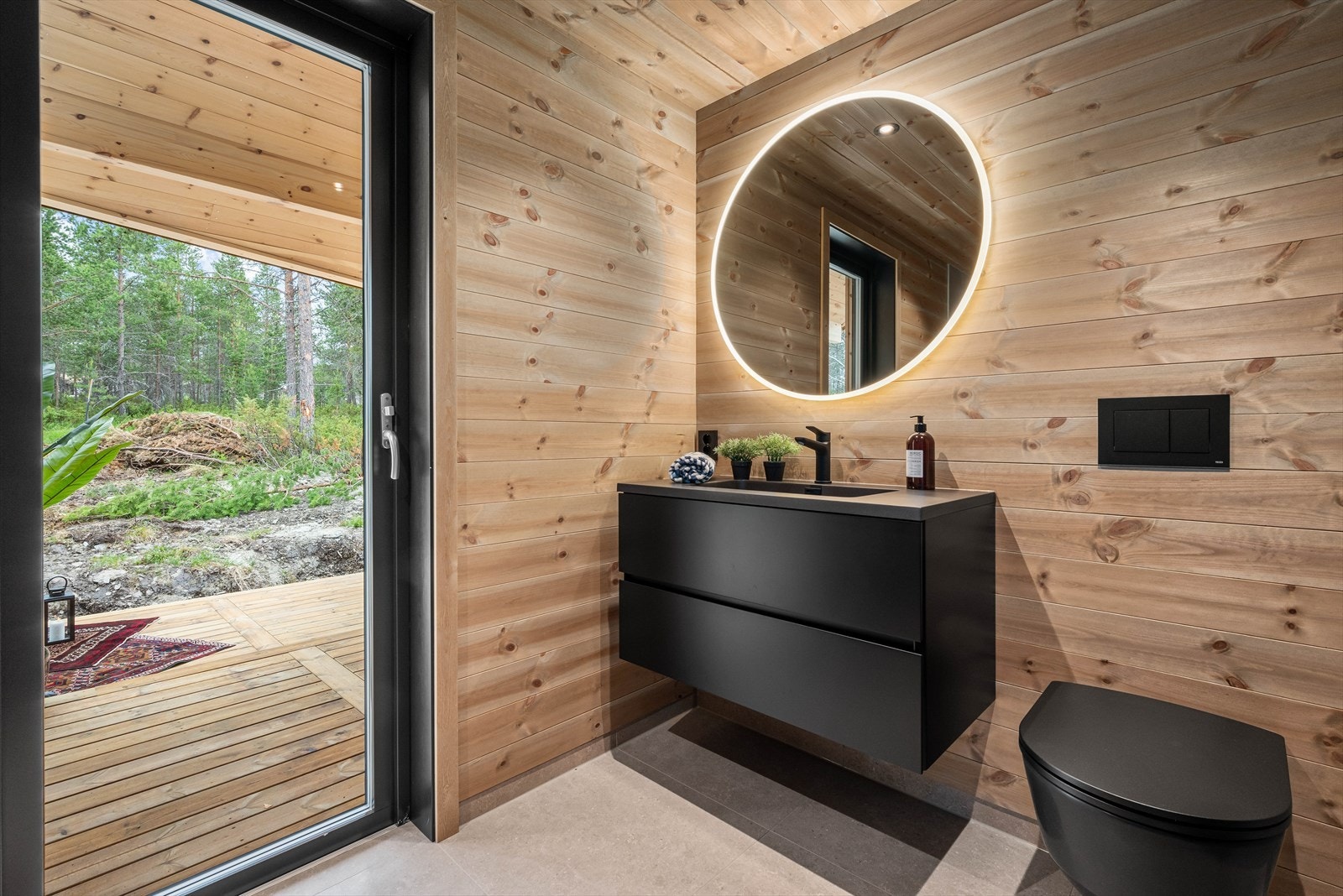 Videre finner du en moderne baderomsinnredning, vegghengt speil og utgang til terrassen. Galleribilde