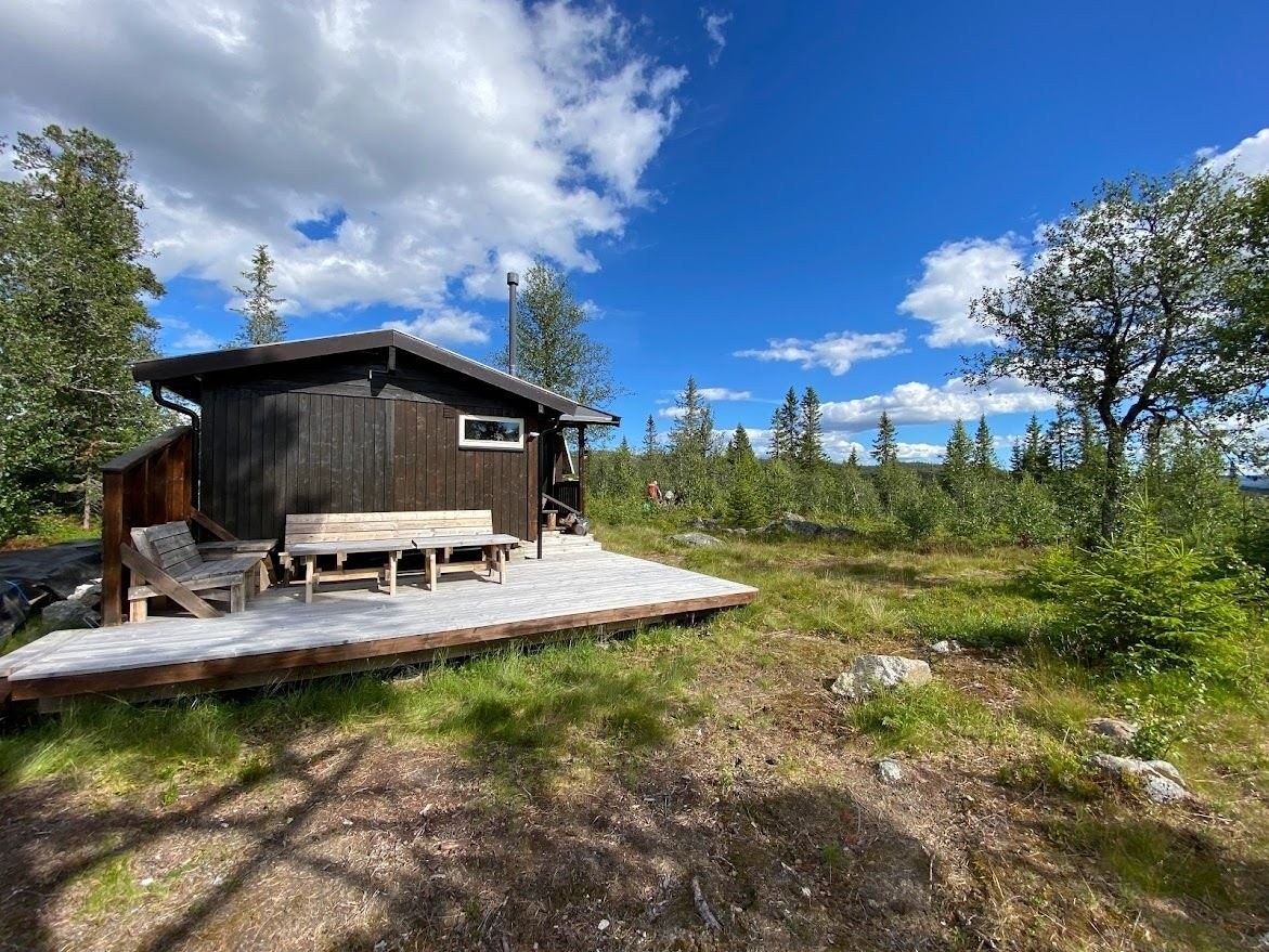 Solrik terasse med utsikt mot skog og fjell. Her nyter du roen og lang solnedgang Galleribilde